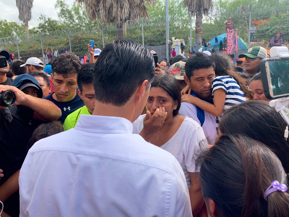Julián Castro speaks with an asylum seeker in a crowd in Matamoros, MX.