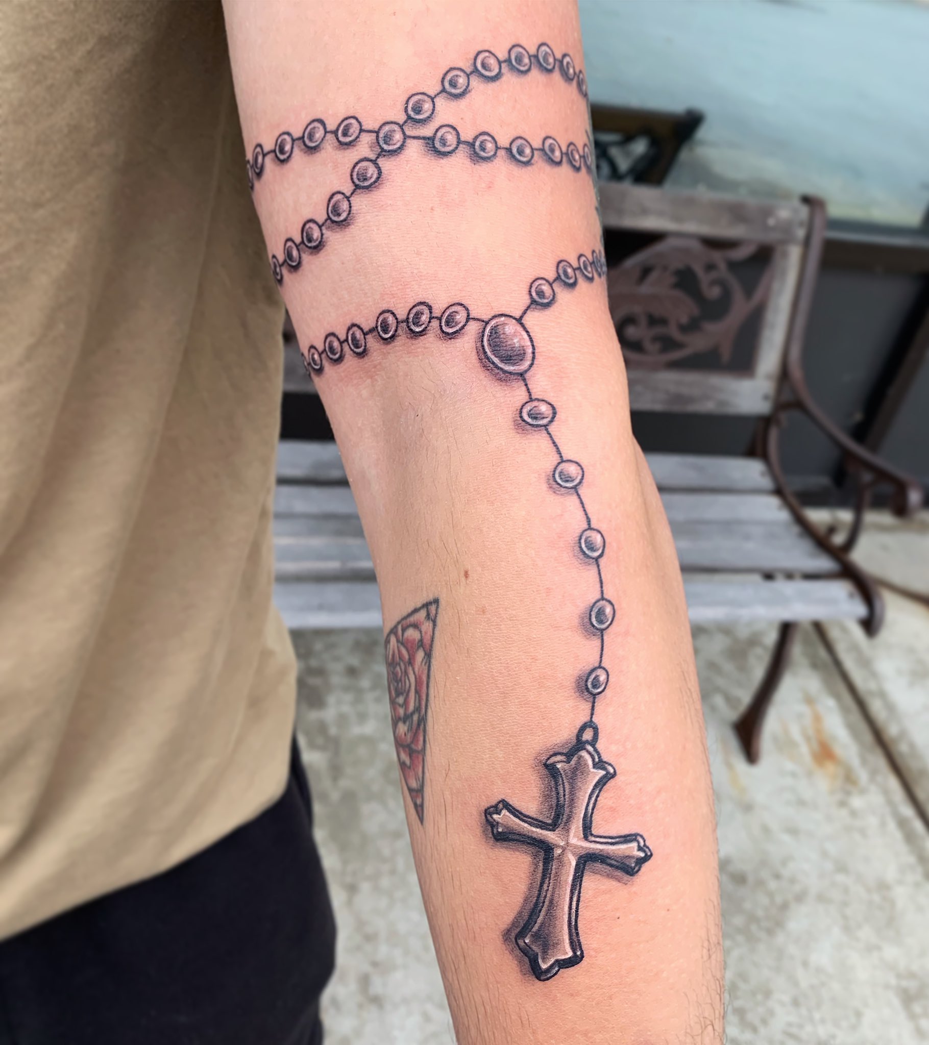 Fine line style wrist wrap rosary tattoo.