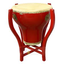 This is a Chinese drum called the 'Flower Pot Drum'. Its supported on a wooden stand and played with pair of drumsticks handmade from the trunk of a small tree.