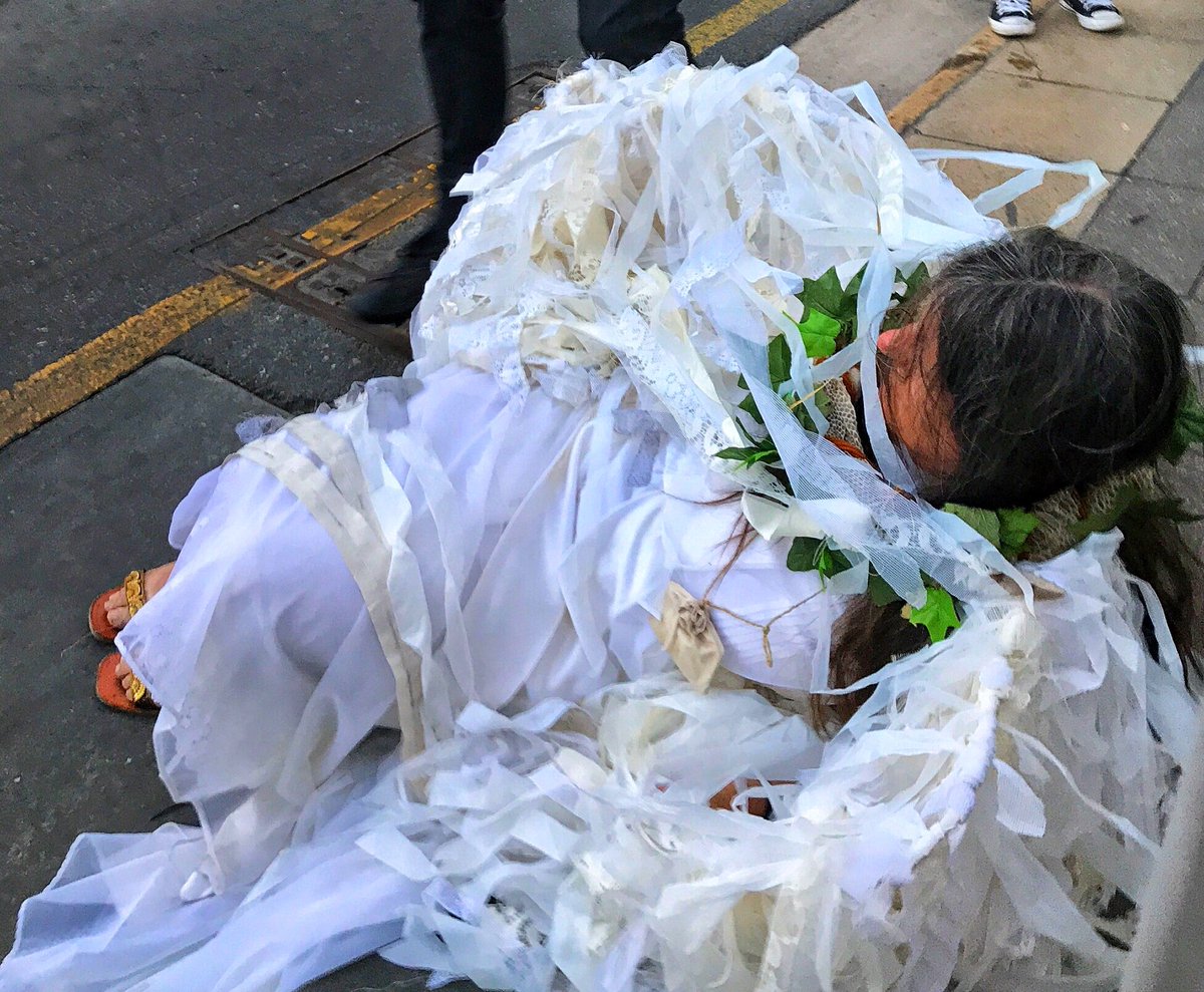 OrsettiTeal's tweet image. Fallen Angel: an one very disheveled Extinction Rebellion Climate Angel attempts to stand after being roughly dragged off the road by police and dumped on the kerb.

@XrSouth #SpringRebellion #ExtinctionRebellion
