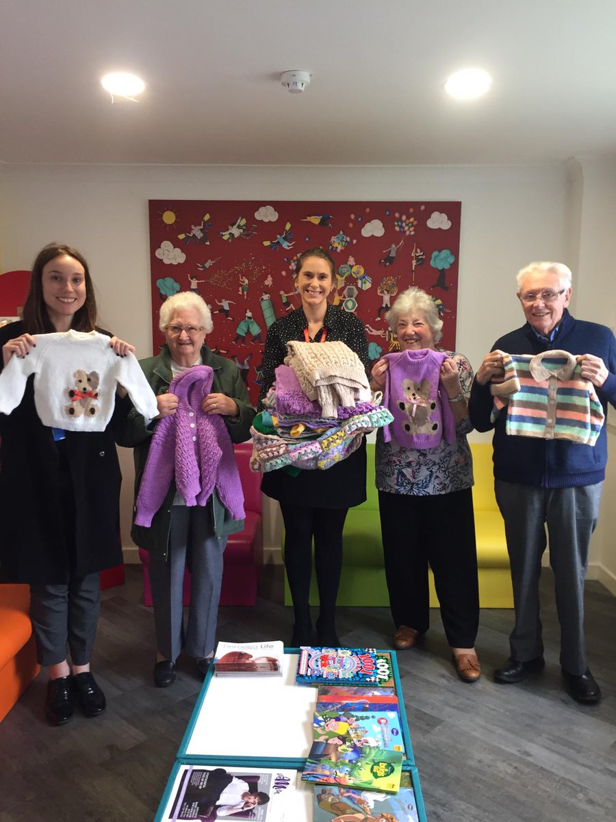 Demelza_Vicky's tweet photo. We're thrilled to have received these wonderful knitted items for babies &amp; small children! These will be sold in aid of 
@DemelzaHospice! #ThankYou to knitting superstar Joyce (second from the left), John &amp; Dorothy - all members of the #MardenThursdayClub! 🧶 https://t.co/s8alnfyqFE