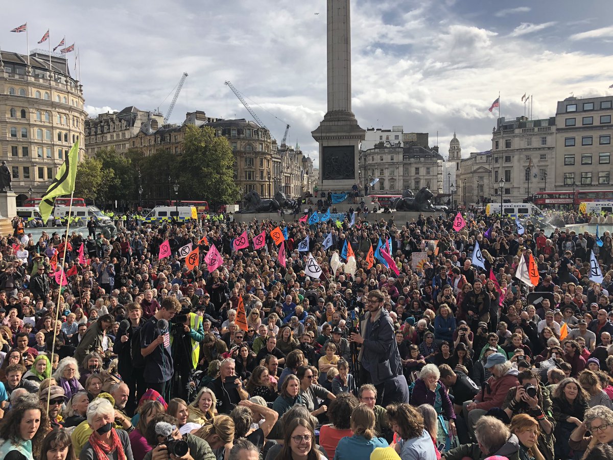 GreenRupertRead's tweet image. There must be 2500 people at least now in Traf Square.
All breaking the law, according to the police here. 
But the Sun’s out. 
Our numbers are growing by the minute.
We are
#ExtinctionRebellion. 
And the Government has lost the high ground to us - by trying to ban us...
Pse RT!