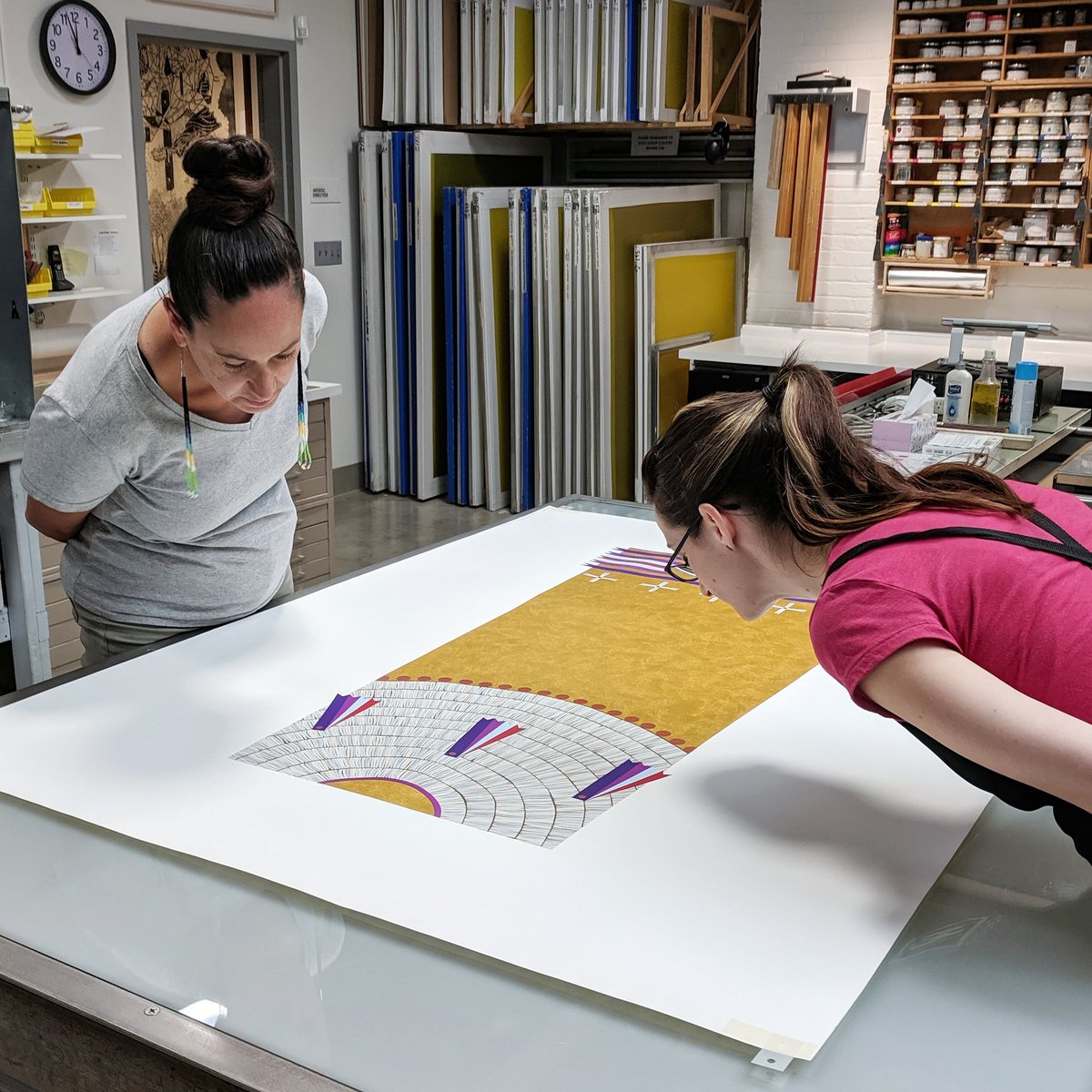 Wókaǧe | Create by Dyani White Hawk features 20 colors, was printed in 32 runs, and took 7 months to complete. We work with incredible artists and our amazing staff of printers to complete intricate, beautiful artwork. Pictured here is Dyani with Apprentice Printer Megan Anderson
