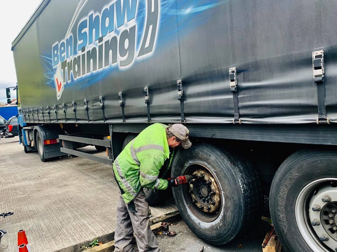 BenShawTraining's tweet photo. Boss Ben’s dad Paul Shaw making short work of swapping a wheel on our artic trailer this evening. 

Farmyard tactics, running the front axle up a kerb, and the back axle up some blocks to take a bit of weight off the middle axle. 🚚👍🏽#teamwork https://t.co/M9CnZfutYS