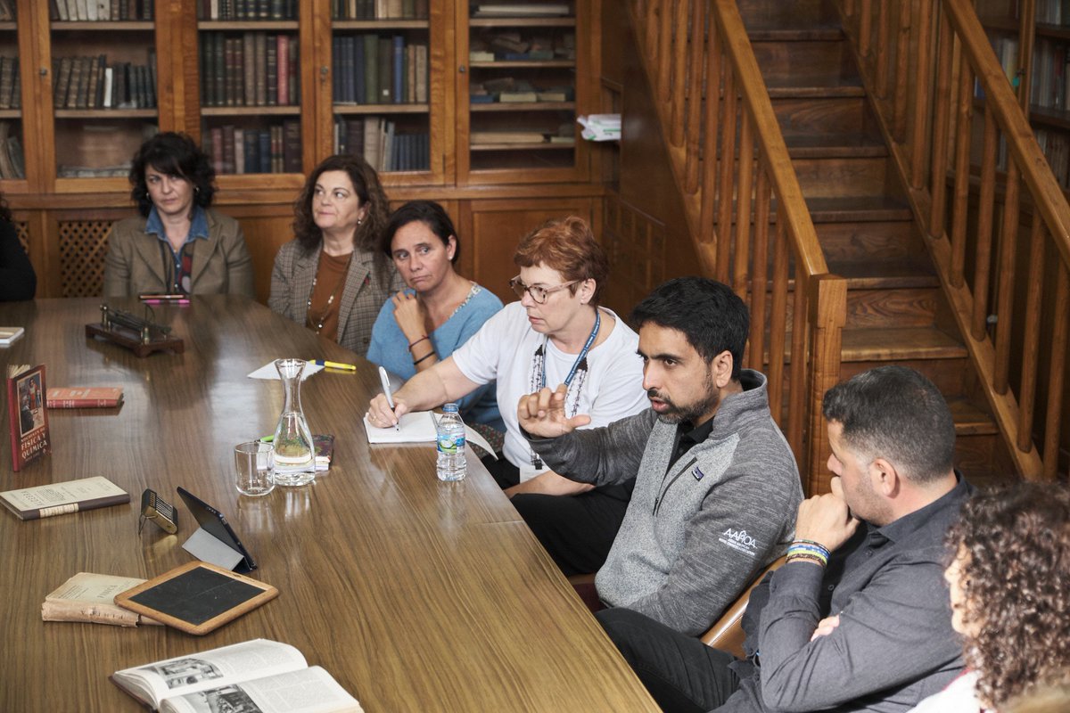 Sal Khan speaks with a group of educators who all sit at a table.
