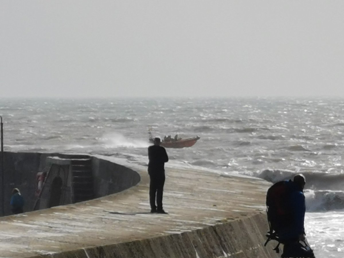 Onlookers from the Cobb wall as lifeboat launched in rough seas this afternoon to a person in the water at Seaton. Volunteer crew launched with 8 minutes and rescued the casualty 200m from the beach.