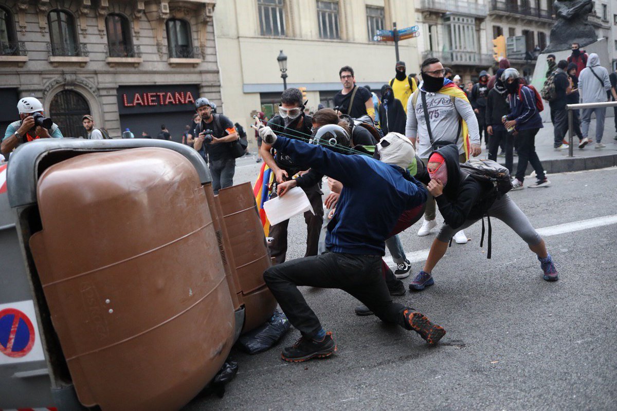 naciodigital's tweet photo. Màxima tensió a Via Laietana. Els manifestants aixequen i cremen una barricada a 200 metres de la prefectura de la policia espanyola, que ja ha disparat salves i ha fet dos carrusels amb mitja dotzena de furgonetes. Imatges de @MartiAlbesa https://t.co/iuEcCvVean #VagaGeneral18O https://t.co/hM9EvYm59A