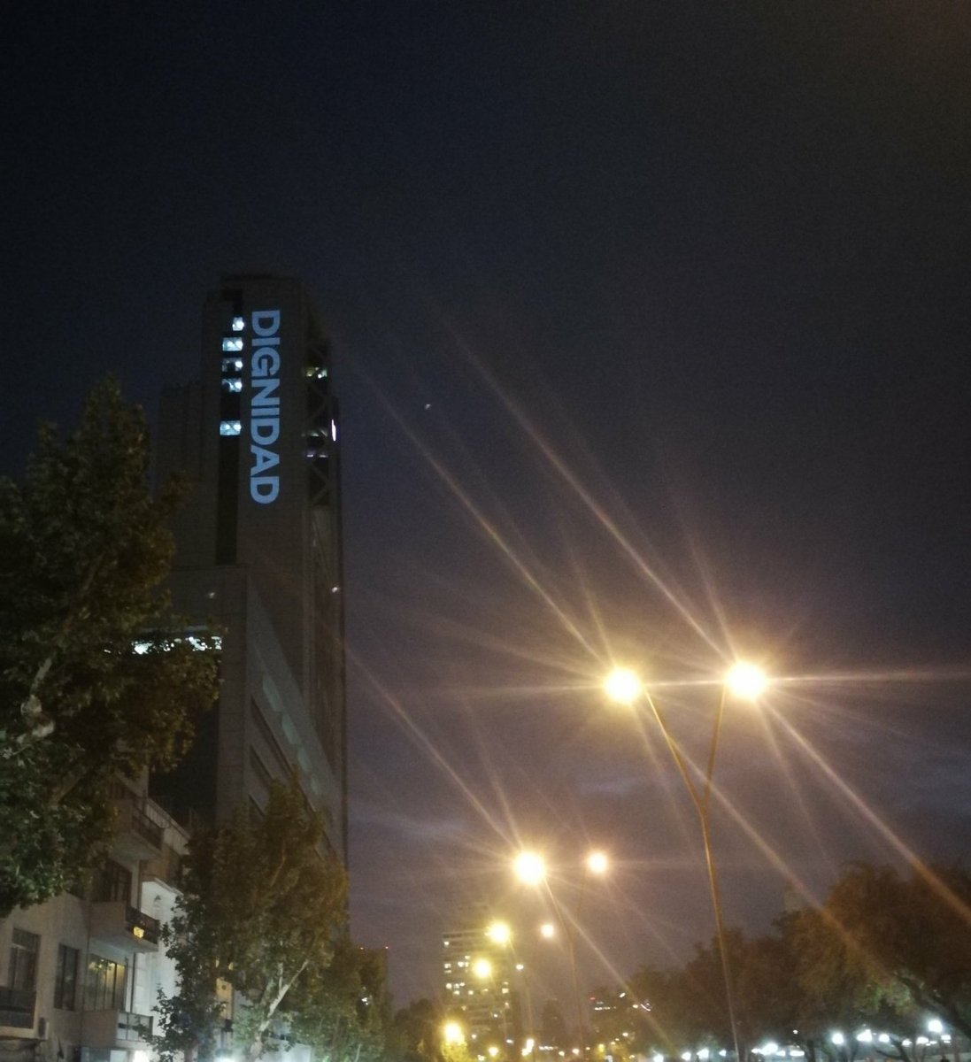 rociomanr22's tweet photo. En la torre telefónica se encuentra proyectada la palabra DIGNIDAD ahora mismo, respeto y admiración al pueblo chileno que despertó✊♥️ #ChileDesperto #ToqueDeQueda #EstadoDeEmergencia https://t.co/pmDn6g2wIo
