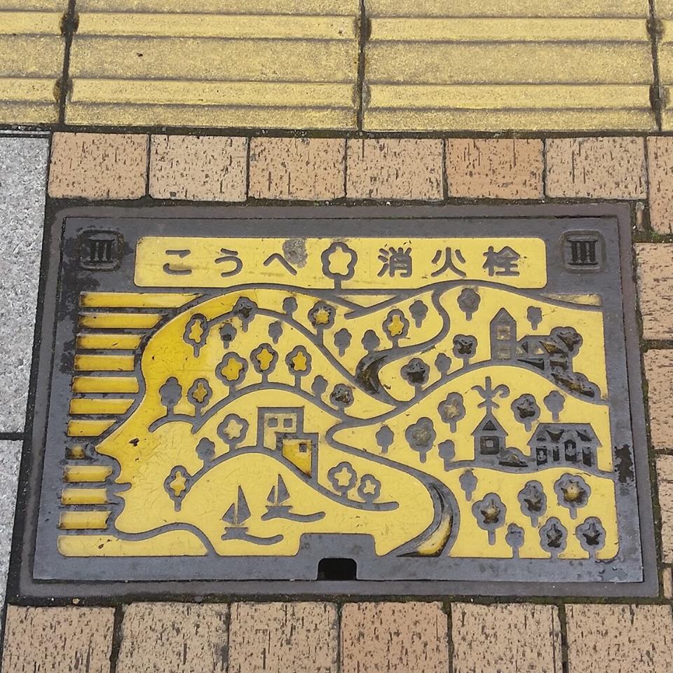 Kitano-cho Kobe Hyogo Manhole cover, showing the hills and colonial houses as a face facing to the sea