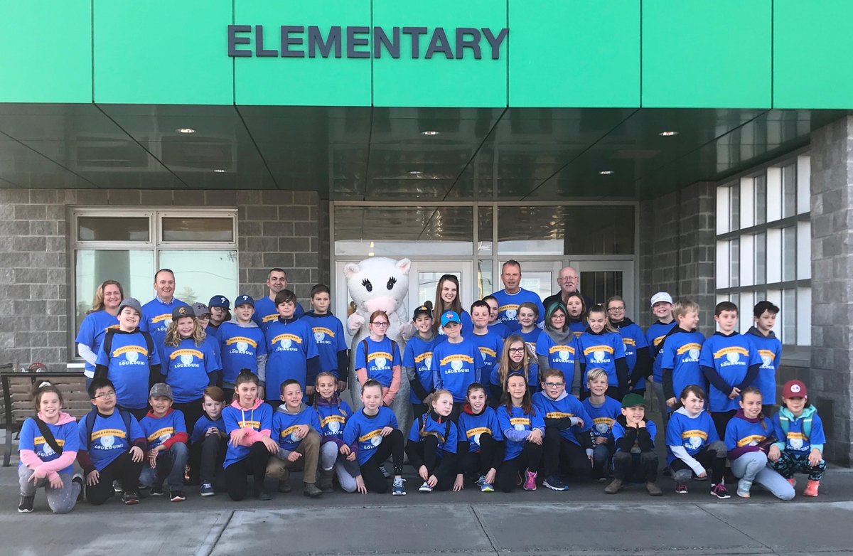 The students of Gander Elementary smiling in front of the school