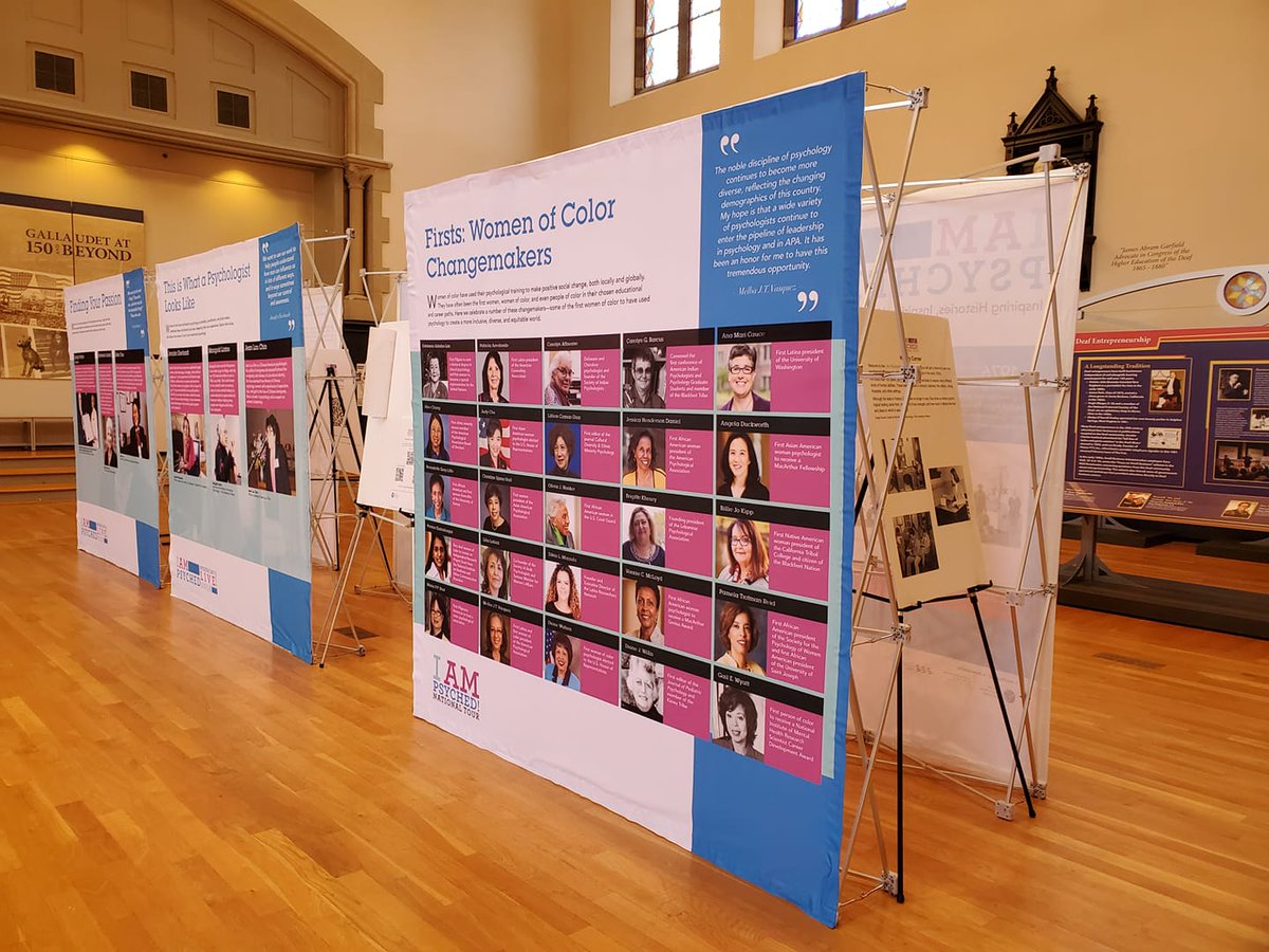 An 8 foot high display tells about women of color in the field of psychology. The stage in Chapel Hall is in the background.