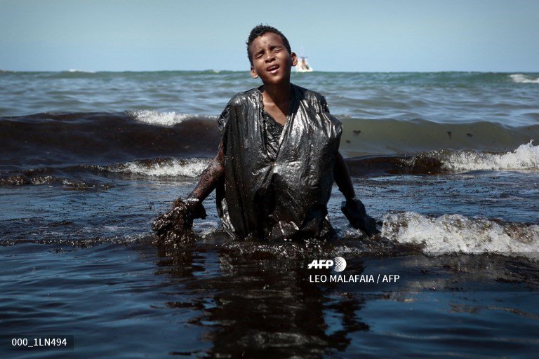 A boy walks out of the sea while removing oil spilled on Itapuama beach located in the city of Cabo de Santo Agostinho, Pernambuco state, Brazil. #AFP 
📷<a href="/leomalafaia/">Léo malafaia</a>