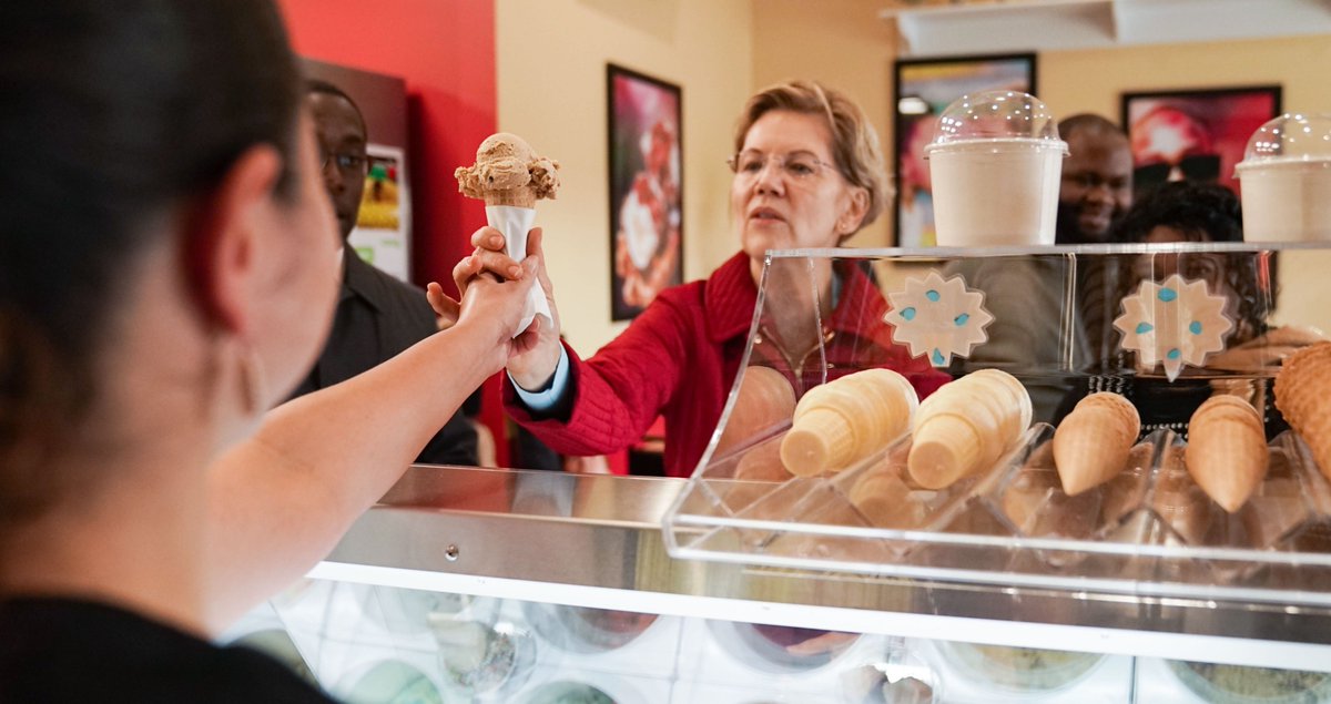 An employee hands Elizabeth Warren an ice cream cone. 