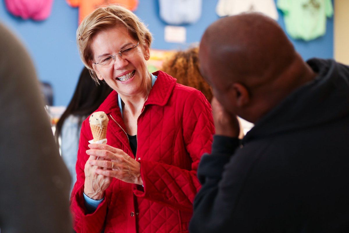 Elizabeth Warren smiles while holding an ice cream cone. 