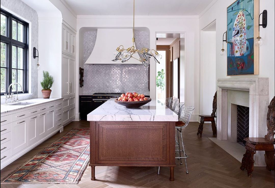 SkoogCo's tweet photo. A kitchen is a place of community as much as it is a place of utility. @souciehorner designs kitchens with the notion that kitchens are the heart of the home—like this sunlit space with its marble-countertop island, fireplace and uniquely modern light fixture. https://t.co/Hm33lQDRE0