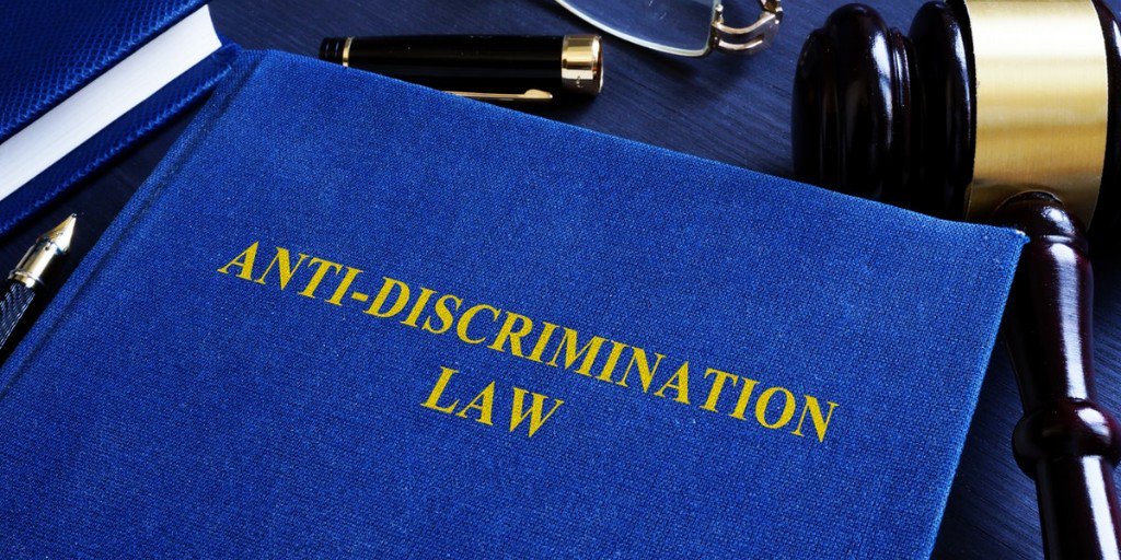 Book with non-discrimination law as title on desk with a gavel