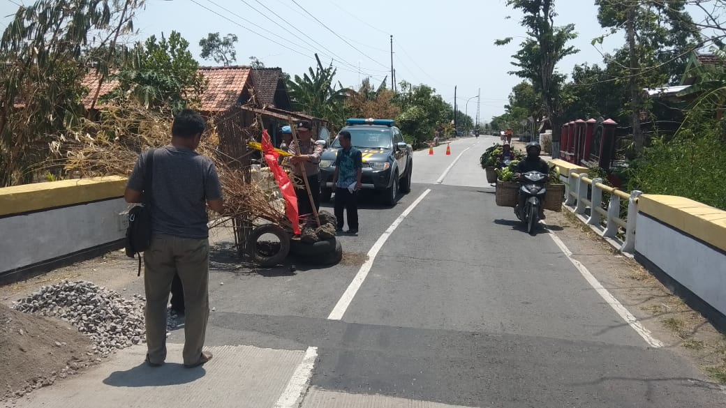 Kapolsek jati polres blora akp bajuri mengecek  jalan propinsi yang rusak dan sekarang di tutup masyarakat dengan bambu karena membahayakan pengguna jalan .