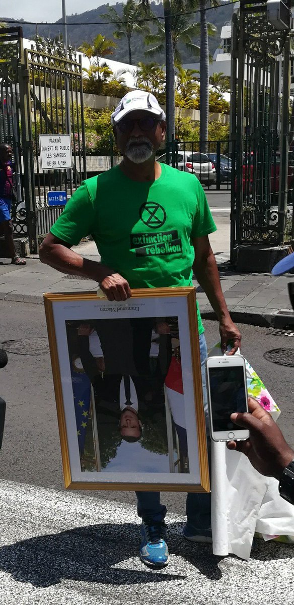 XR Réunion a "emprunté" le portrait de Macron de la ville de Saint Denis en plein visite présidentielle pour rappeler son inaction climatique !