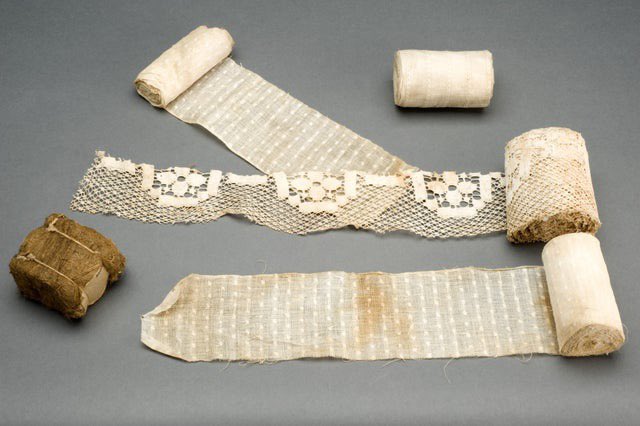 مجموعة من بدائل الضمادات الجراحية المستخدمة خلال الحرب العالمية الأولى بسبب النقص بما في ذلك قماش الستارة والشاش والقطن والقطن المستخدم في التنورات الداخلية والطحالب.  1914-1918م. 
D