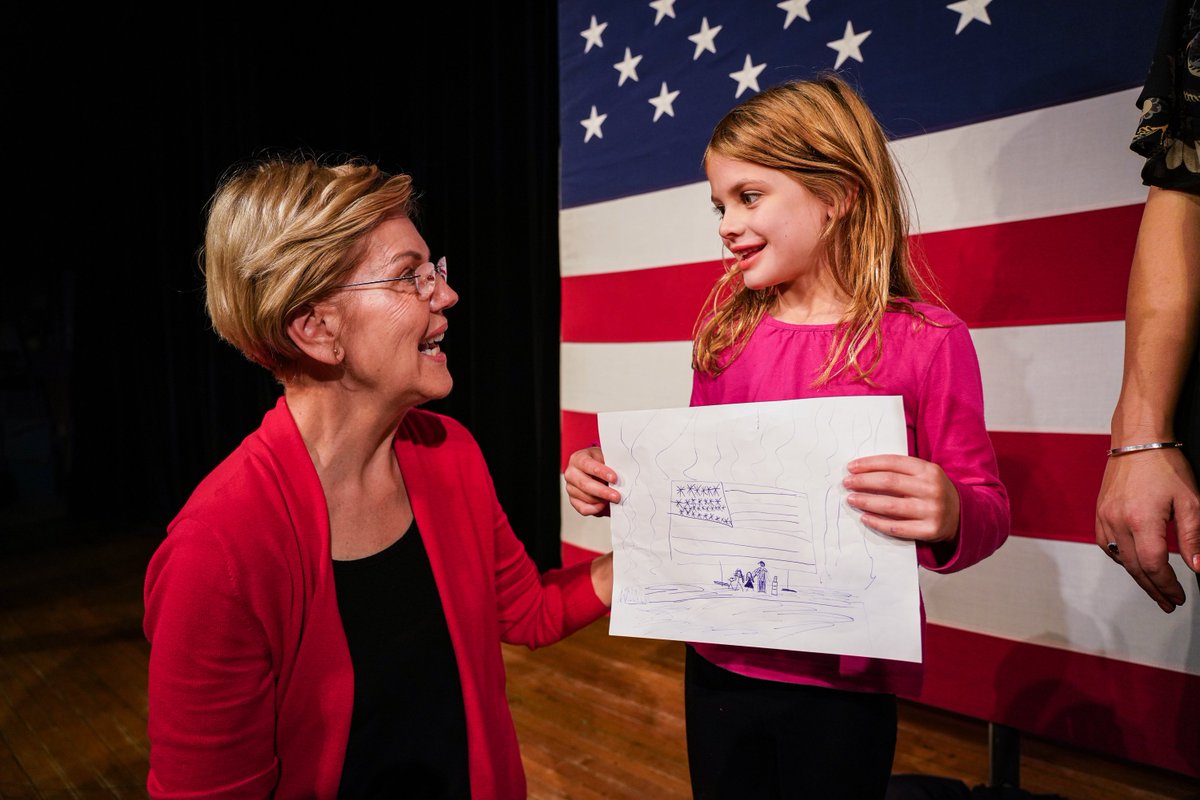 A young girl shows her drawing to Elizabeth Warren.