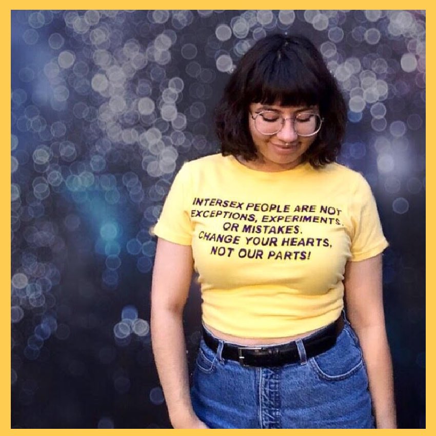 Picture of a beautiful person wearing a yellow T-shirt with black text design Intersexpeopleare not exceptions, experiments or mistakes. Change your hearts not our parts