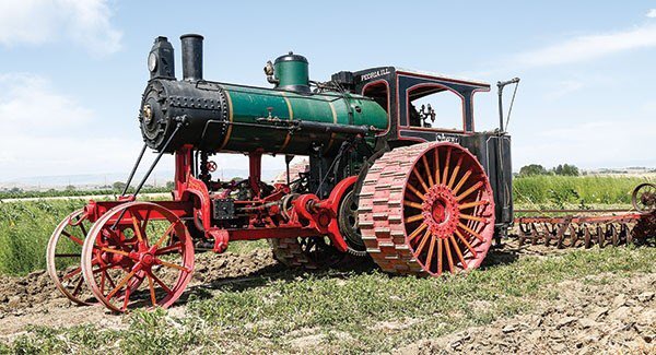 A picture of a steam powered farm tractor with tiller attachment