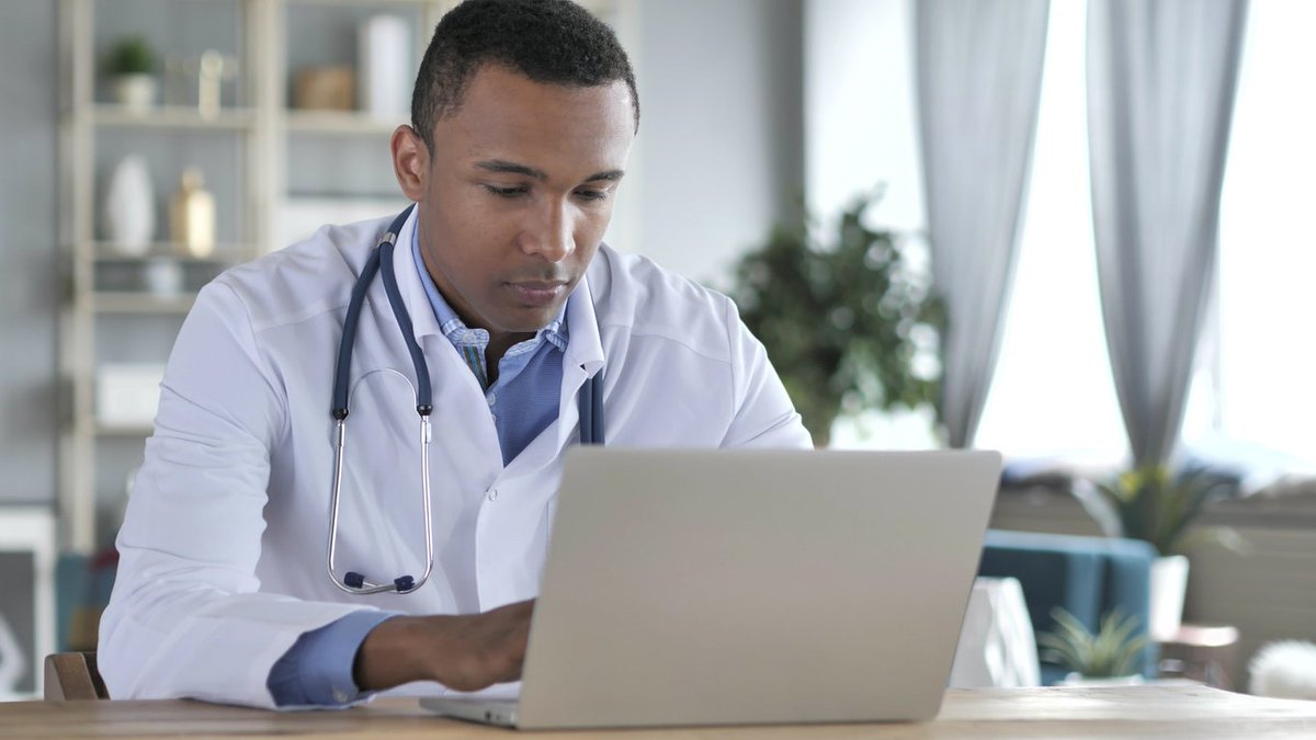 A doctor working on a laptop. Image credit: iStock