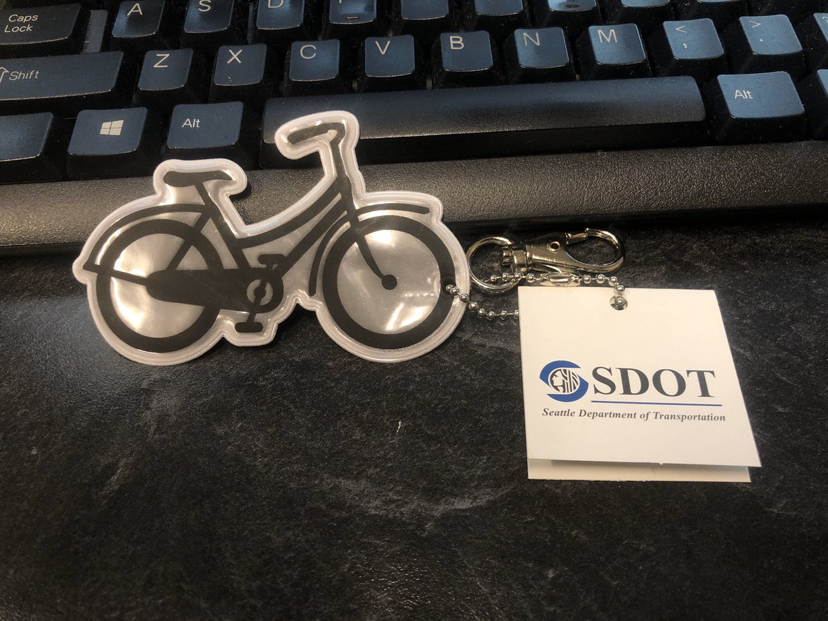 Bicycle keychain with SDOT tag sitting on a computer keyboard
