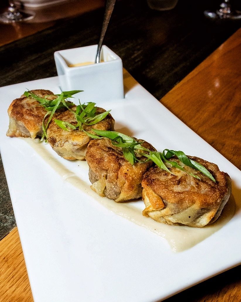 Start with a fam favorite: Cheesesteak Dumplings with onion purée and cheese fondue. #crushmgm