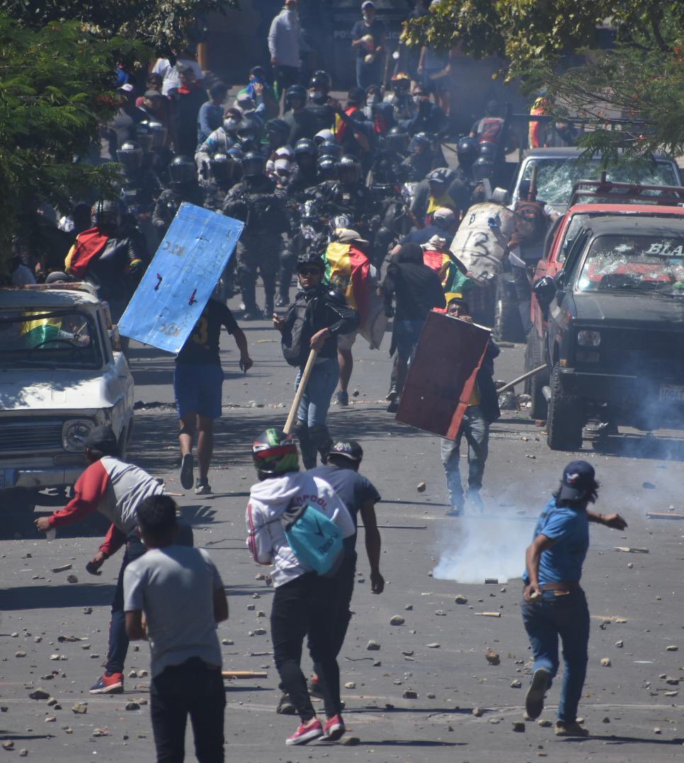 Opinion_Bolivia's tweet photo. El historico Pueblito de #Cochabamba se ha convertido en campo de batalla. Hay  varios vehículos destruidos, heridos y otra moto quemada. Los enfrentamientos en la zona de la Muyurina continúan.
📸 Dico Solís. https://t.co/VFga3Wc0AC