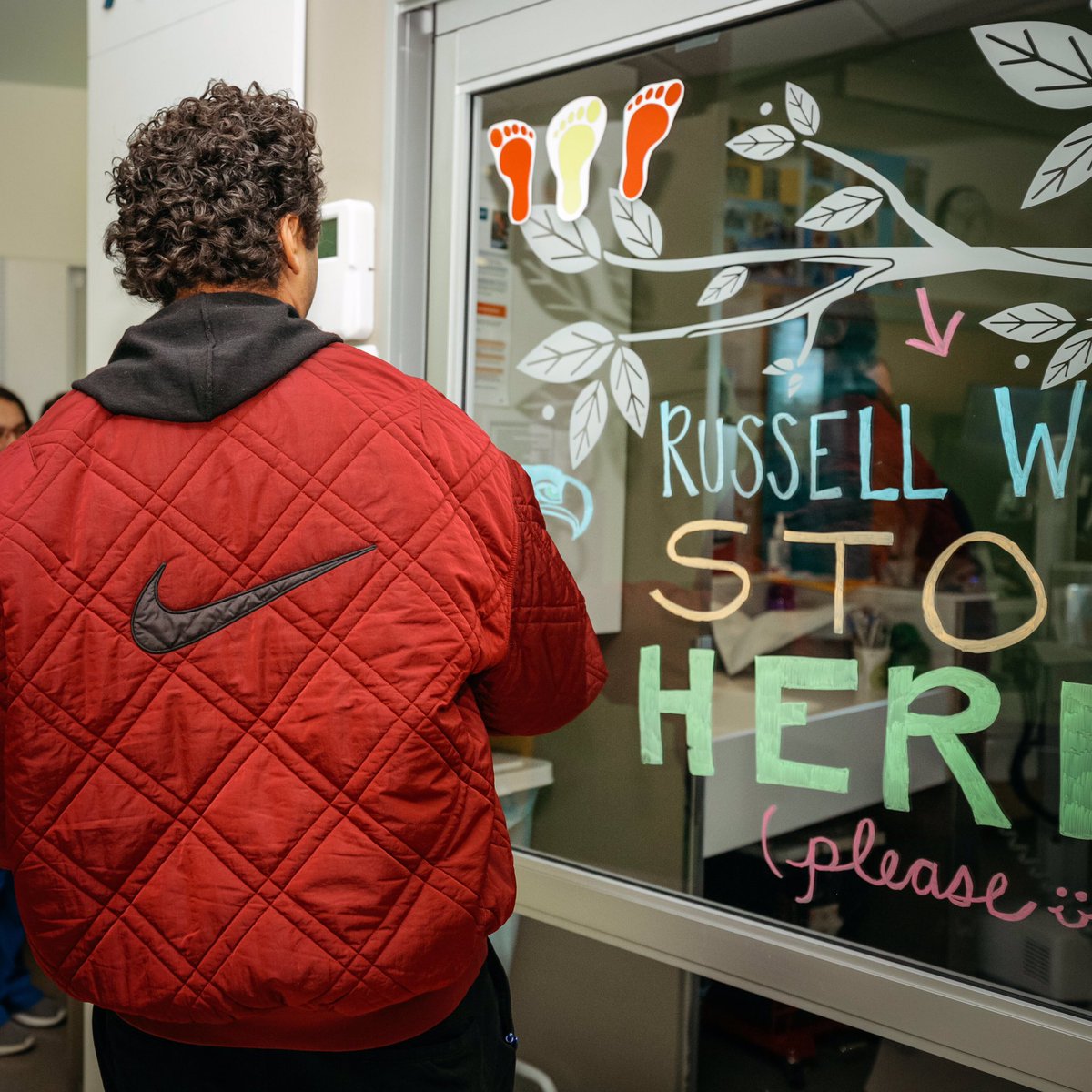 seattlechildren's tweet photo. Imagine seeing a huge sign on a patient’s door with your name and “STOP HERE (please)!” This is what greeted @DangeRussWilson today and stop he did. Inside Jackson was ready sporting his #3 @Seahawks jersey. They celebrated a huge milestone for Jackson - transplant day! https://t.co/kXCZYIBKXl