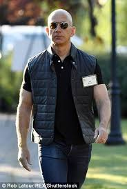Jeff Bezos in a vest showing off them guns.