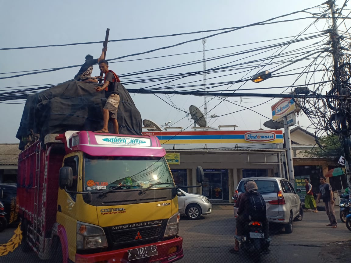 Salah truk muatan terlalu tinggi,   tapi kabel awur awutan...tiang Telkom tempat numpang semua kabel...tapi Telkom tidak pernah ngurusin,  #telkom