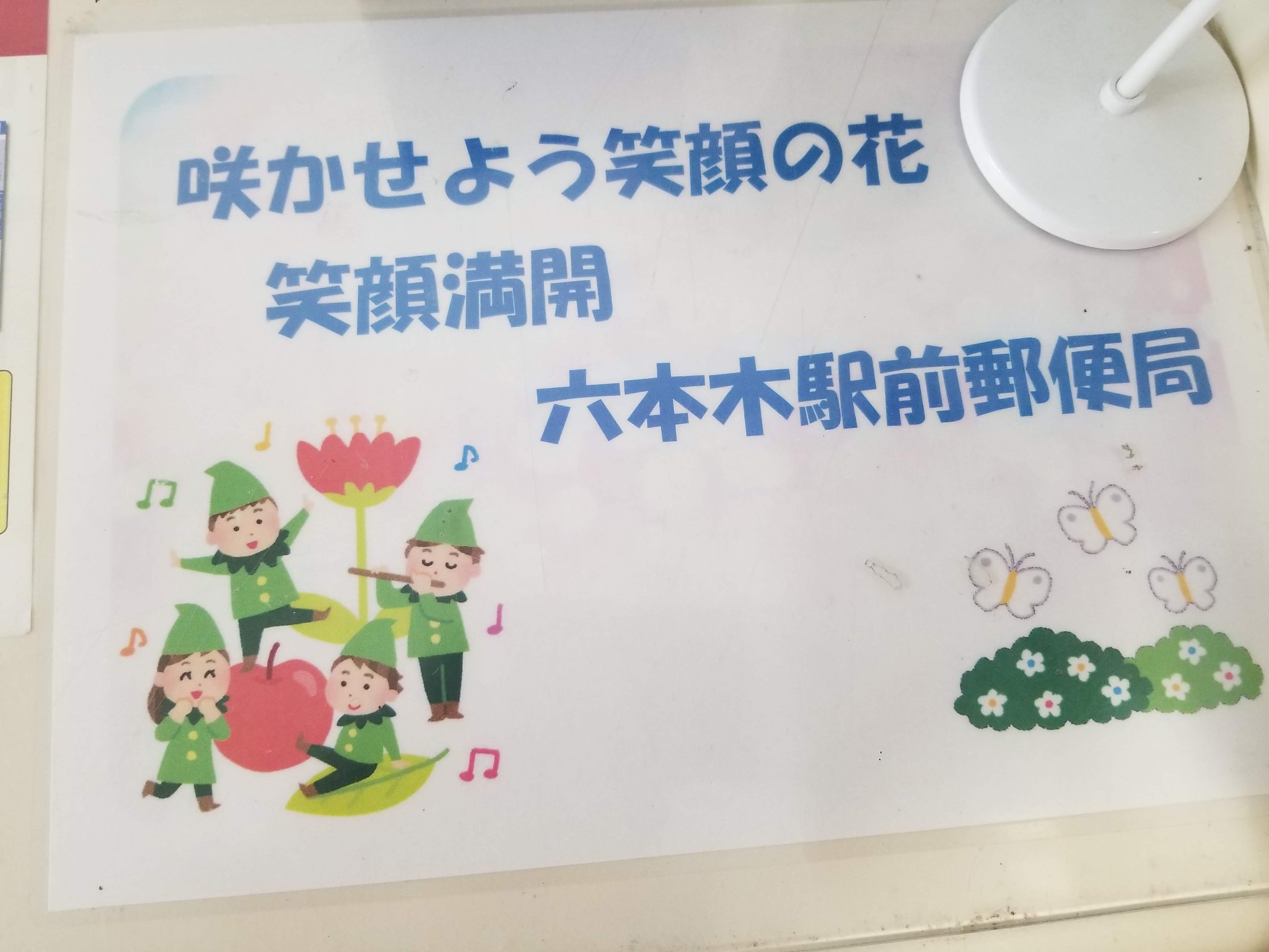 三浦靖雄 登録325号は六本木駅前郵便 局の宛名を書いたりする作業台の飾り 花の下で小人たちが楽しそうに 音楽を演奏したり踊ったりして遊んでいるイラスト という独特の素材チョイスが郵便 局感あります