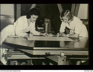 WomenAtWarBot's tweet photo. c. 1944. Two women work at a table on a Taylor-Hobson profile projector used for checking measurements of gauges and components. They are possibly employed at the Commonwealth Munitions Supply ..: https://t.co/h96CsOKODB https://t.co/2jM6i6hWjt