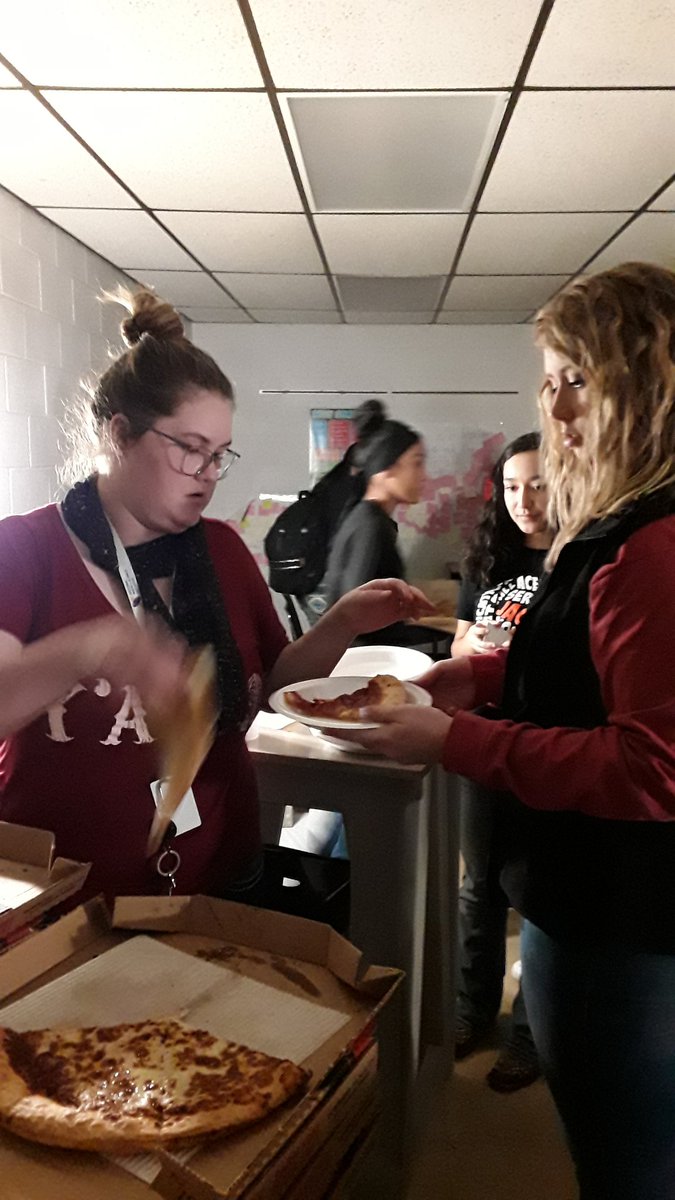Coach mikulak and Mrs.Newman  serving pizza to their classes after winning the door decorating contest.