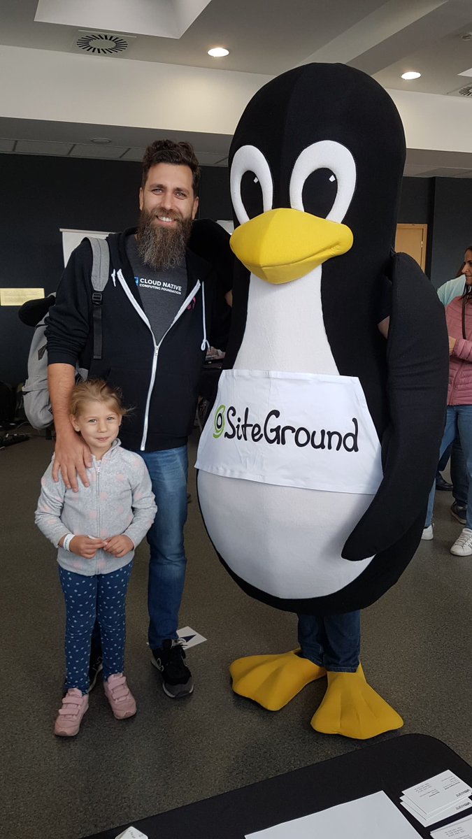 OrlinVasilev's tweet photo. Me and my little girl geeking out at @openfestbg #openfest2019 with #tux :)) proudly wearing my @CloudNativeFdn ambassador swag :) BTW she loves Tux :) https://t.co/vh8t4lQLO3