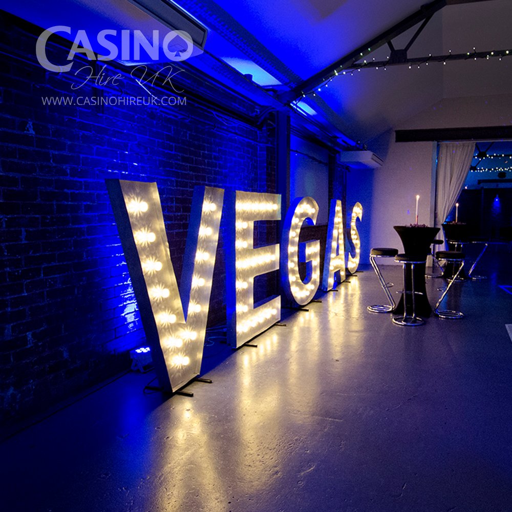 Vegas themed party with blue lighting, roulette, blackjack and poker.