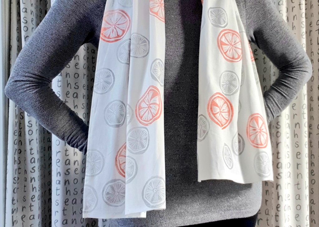 Hand-printed scarf by Ali Savic PRINTS. Linocut Prints in orange & grey. #linocut #HandmadeHour #handmade #nothingtowear #fashion #scarf #blockprinting #designtwitter #textiles #fabricprinting