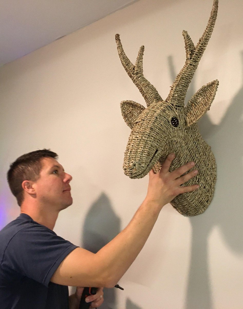 A CPSC staff member named Greg mounting a wicker deer head on a wall. The deer is also named Greg. This is a coincidence.