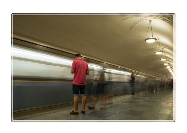 A man on his #phone perfectly still as the #world passes him by on the #Moscow Metro #publictransport #moscowmetro #moscowmetrostation #moscowmetropolitan #Russia #PictureOfTheDay for more see https://www.darrensmith.org.uk/Portfolio