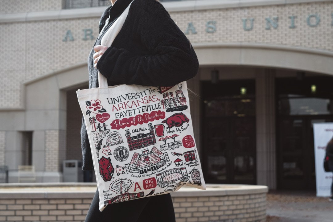 This bag is tote-tally awesome. Designed by Julia Gash, this design highlights spots in Fayetteville and <a href="/UArkansas/">University of Arkansas</a>  🐗❤️ Available in-store and online bit.ly/2KEumX2