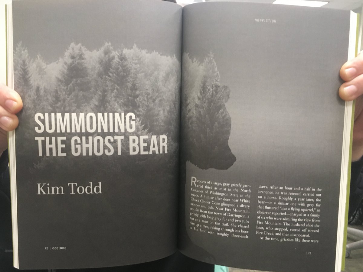 An open magazine, with a black and white picture of a grizzly bear made of smokey evergreens, behind the title and text