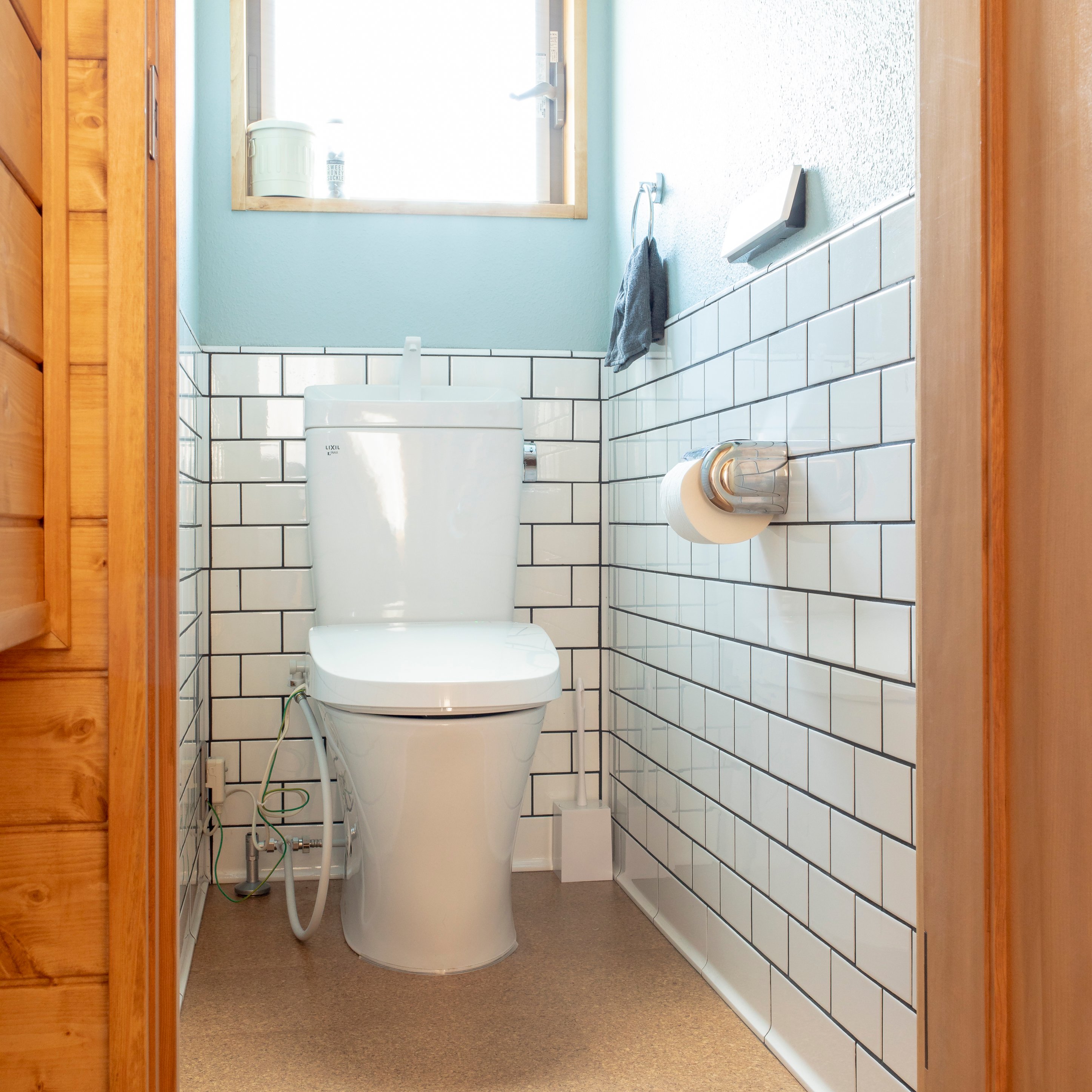 タイルパーク サブウェイタイルでカッコよく仕上げたトイレ空間 青い壁と木の建具とも相性抜群 タイルで仕上げると 自宅のトイレがまるでカフェのお手洗いのよう タイルパークアワード タイル タイルパーク サブウェイタイル Suw150 トイレ