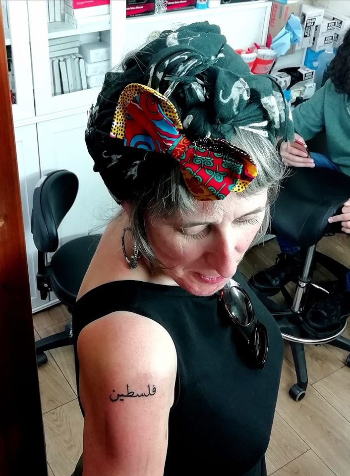 PalCommunityUK's tweet photo. Two #JustCycle riders, Anne and Natalie, were so touched by #Palestine they had the word inked onto their bodies at the end of the trip. Getting them at #Razzouk Tattoo Parlour in Jerusalem's Old City. Tattooing has been in this Christian Palestinian family for 700 years. #tattoo https://t.co/TWu2IJxGEP
