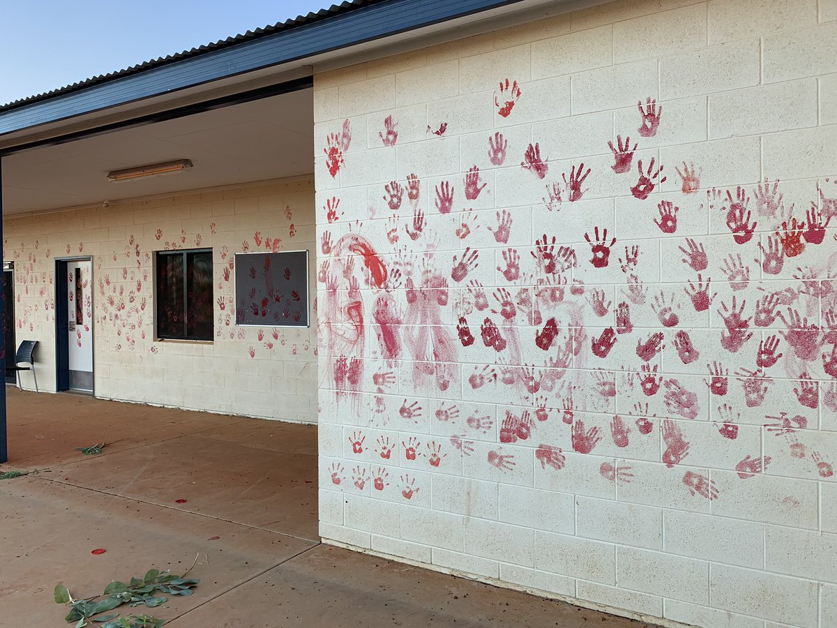 Young people have painted red handprints on the Yuendumu police Station, community members still pouring through the station for smoking ceremony (still peaceful)