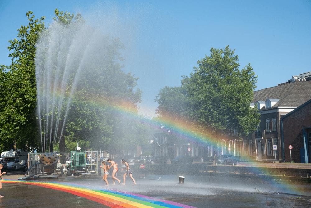 Een regenboogpad langs het water. De uitwerking van dit idee fleurde de hele kade op tijdens FM18. Op de achtergrond de stralen van de Waterbaan die Noordkade en Julianapark verbond. Ook zo'n geweldig idee? Meld je aan voor FM20 op 10, 11 en 12 juli 2020: fabriekmagnifique.nl