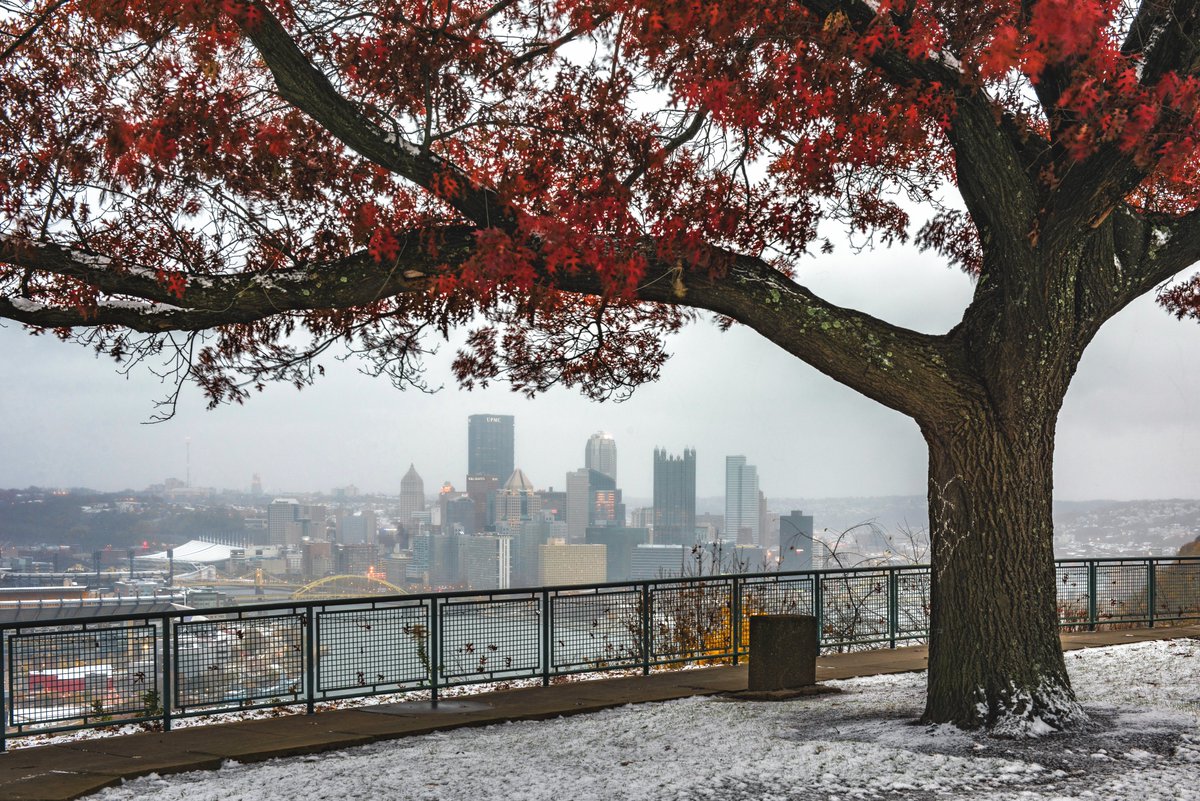 DaveDiCello's tweet photo. Snow falling while there are still leaves on the trees can make for beautiful images. This is probably my favorite combination of the two that I've ever captured in #Pittsburgh, with the bright red standing out against the dusting of snow on the West End. https://t.co/AyH5Xr0jep