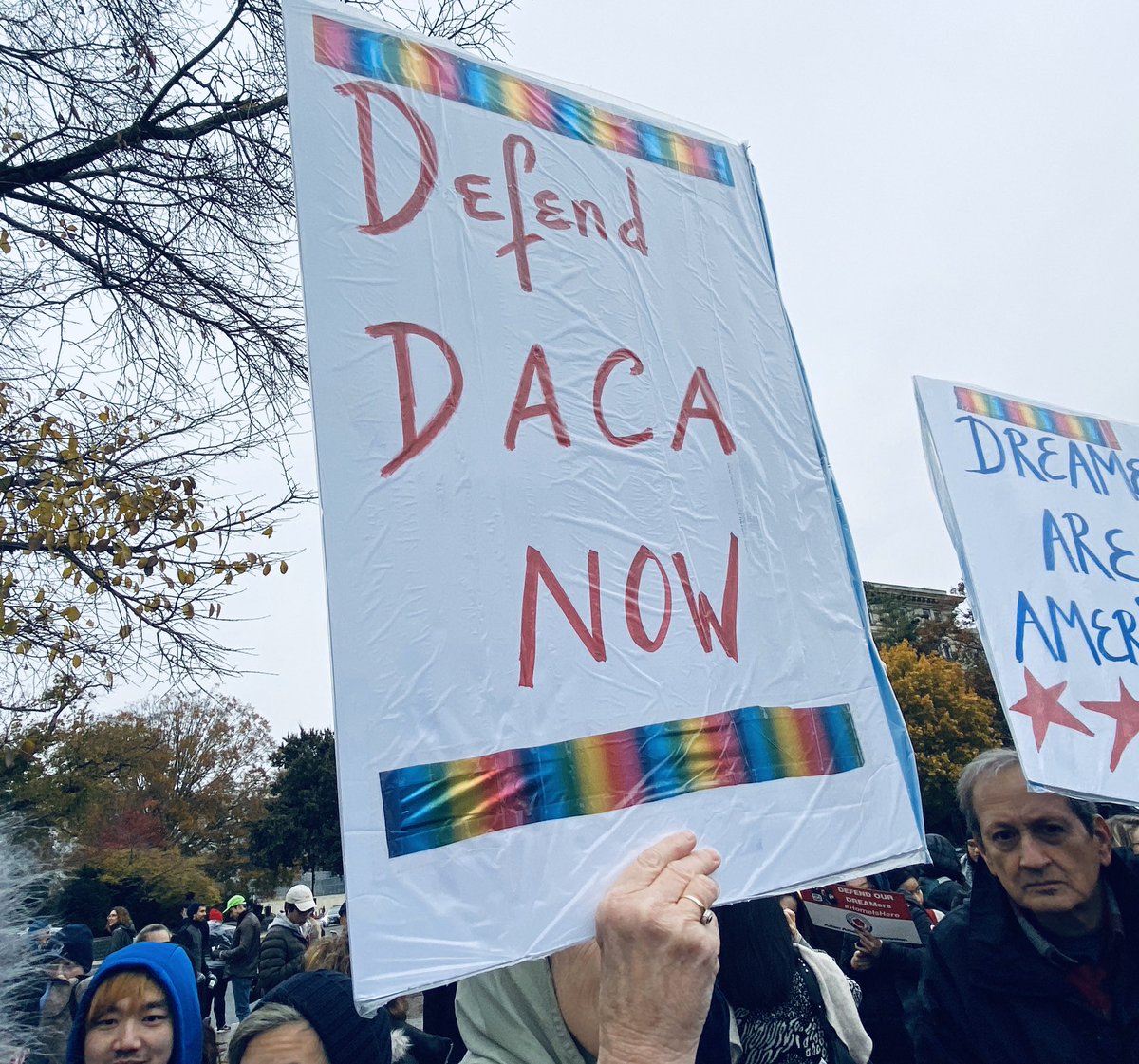 Sign says “defend DACA now.”