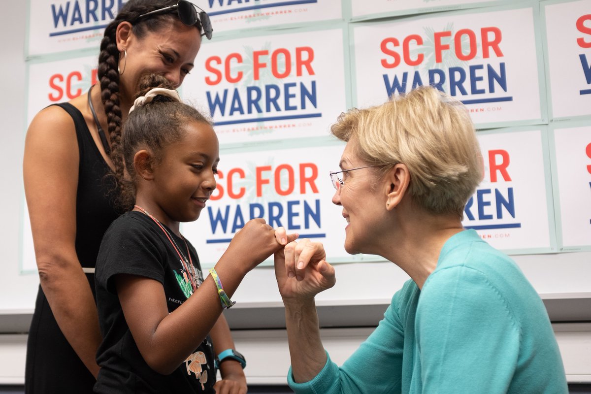 Elizabeth Warren makes a pinkie promise with a young girl.